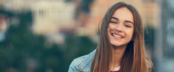 Young woman with straight smile after Invisalign treatment