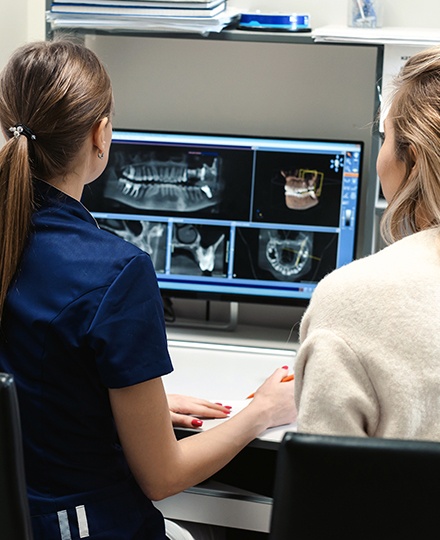 Dental team members examining digital x-rays